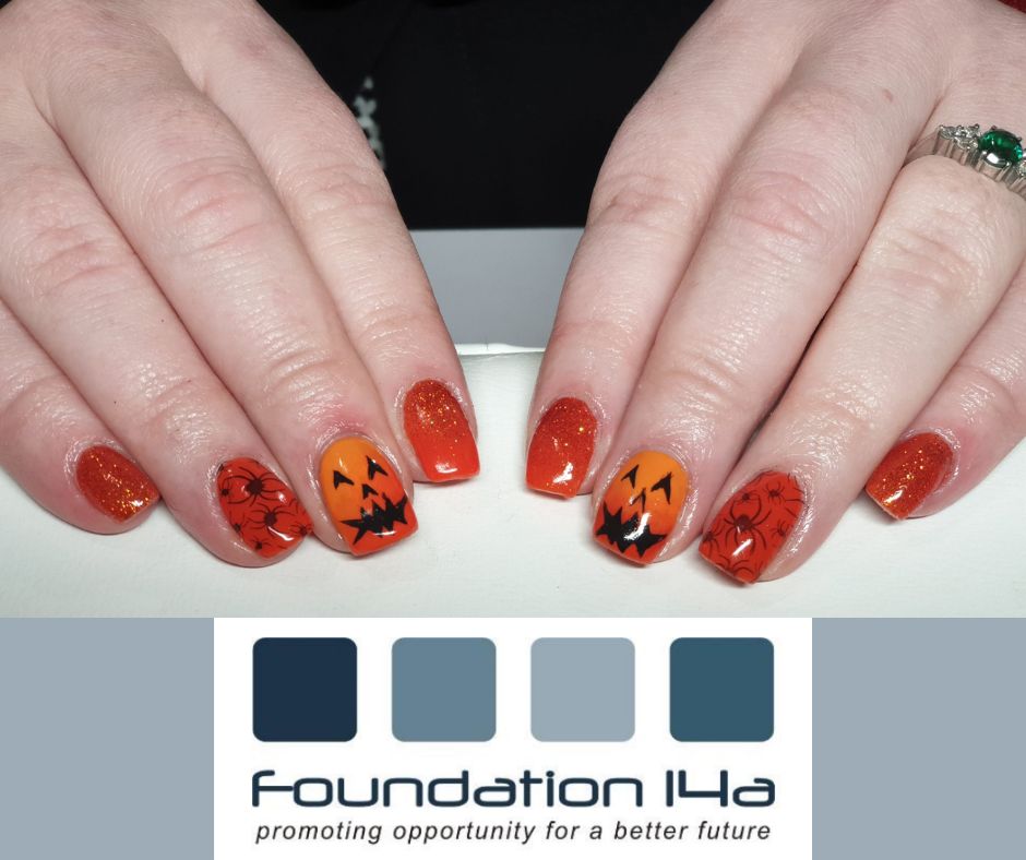 A lady's fingers displaying nails painted in a Halloween design